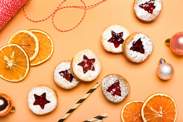 Tasty Linzer cookies with Christmas decor on color background