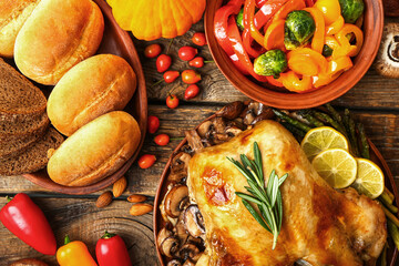 Tasty baked turkey and different food for Thanksgiving Day on wooden background
