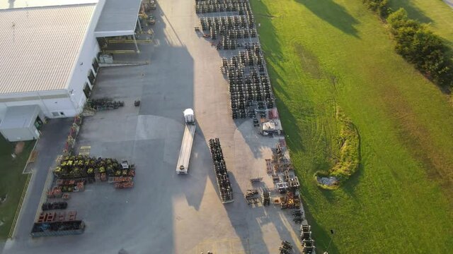 Aerial View Of An Empty Flatbed Semi Truck Driving At Warehouse Yard. orbiting