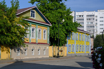 Fototapeta na wymiar City street with an old wooden house in national style in Kazan, Russia, early in the morning