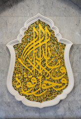 KAZAN, RUSSIA - 17 AUGUST, 2021:Arabic letters laid out in gold mosaic on the marble; wall of the...