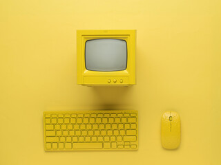 Yellow monitor, keyboard and mouse on a bright yellow background. Flat lay.