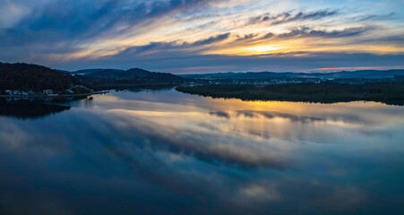 Fototapeta na wymiar Sunrise and cloud reflections panorama waterscape