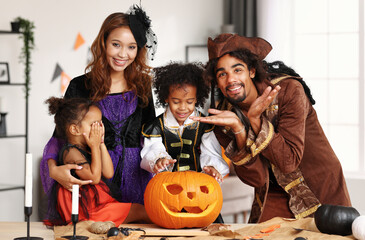 Happy african family parents with kids preparing Halloween decorations at home