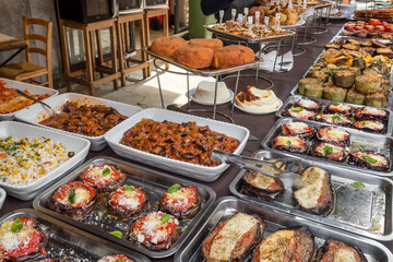 Grilled vegetables, stuffed eggplantand, local street snacks on a stall of traditional farm market in Sicily, Italy