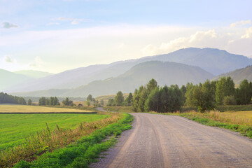 Fototapeta na wymiar Gravel road in a mountain valley