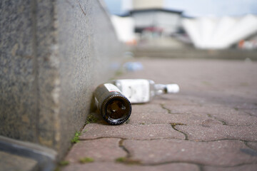 empty liquor bottles on a sidewalk at Alexanderplatz in the center of Berlin