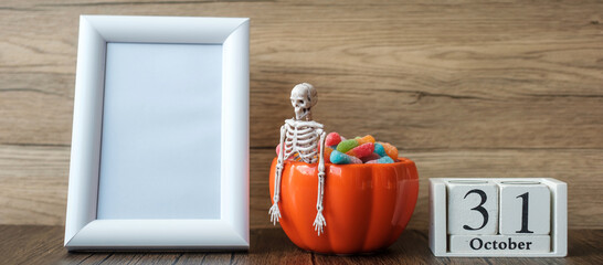 pumpkin bowl of candy, 31 October calendar and frame with copy space for text. Happy Halloween day,...