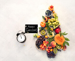 Christmas tree made of fruits on light gray background.
