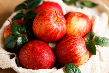 red apples in white plate on  wooden table.