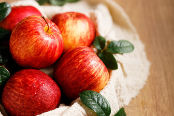 red apples in white plate on  wooden table.