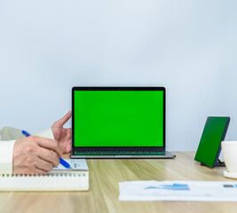 close up green screen on laptop with working environment and copy space