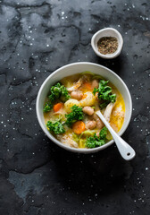Tuscan style thick chicken, bean soup on dark background, top view