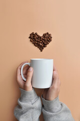 A cup of coffee and a heart of coffee beans over it . A symbol of good morning. Love for coffee
