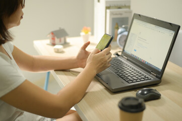A woman working from home using a smartphone.
