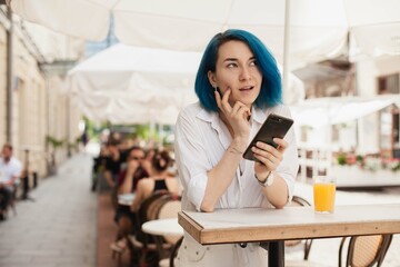 Stylish young woman thinling on a restaurant terrace, feeling happy on a summer day