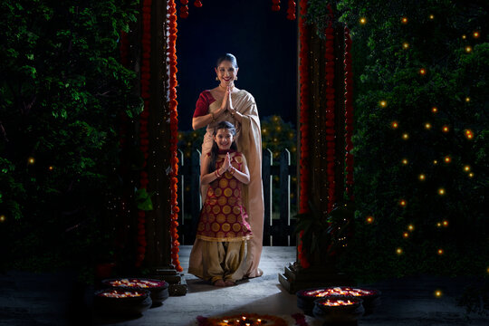 Mother and daughter greeting together with their joined hands on the occasion of Diwali