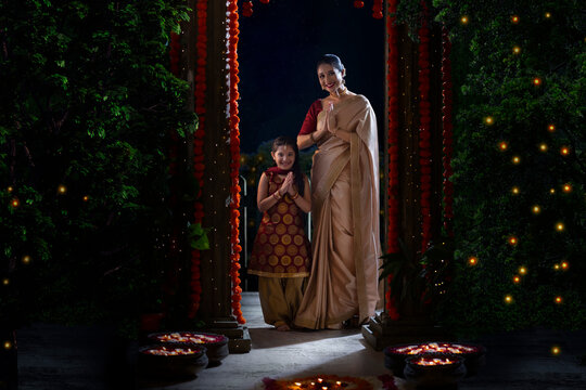 Mother and daughter greeting with their joind hands on the occasion of Diwali