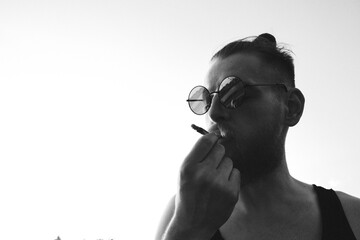 Daring young man smoking cigarette outdoors