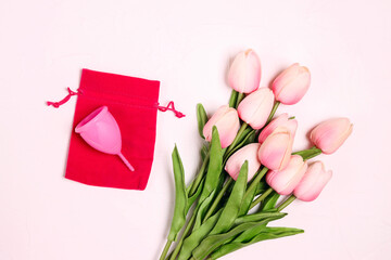 Pink menstrual cup with tulips on a white  background.