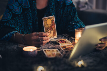 Fortune teller showing tarot cards online. Online tarot cards with tablet or smartphone. Astrologists and horoscope online concept. - obrazy, fototapety, plakaty