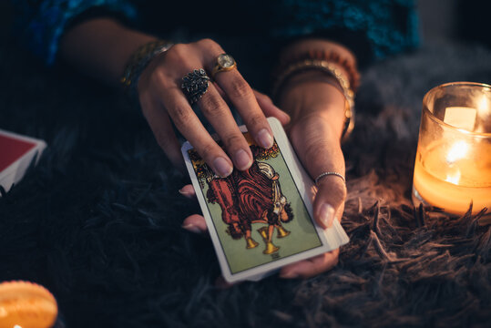 Fortune teller holding tarot cards deck. tarot cards and burning candles. Astrologists and forecasting concept.