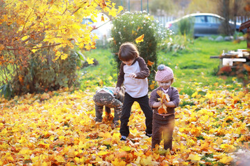 Young family on a walk in the autumn park on a sunny day. Happiness to be together.