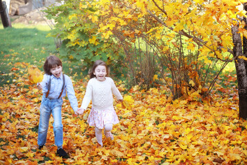 Young family on a walk in the autumn park on a sunny day. Happiness to be together.