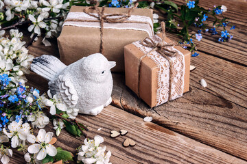 Apple blossom, gifts and bird on old wooden boards.