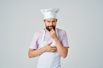 a bearded man in a chef's uniform gestures with his hands the emotions of professionals