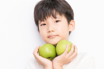 little boy  holding green apple.