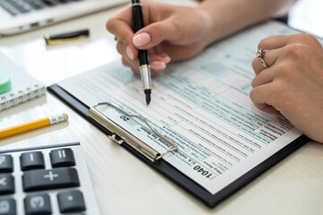 Human hands with 1040 tax form closeup. Taxation concept