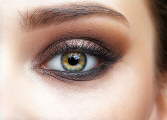 Obraz premium Closeup macro shot of human female eye with pink eyes shadows