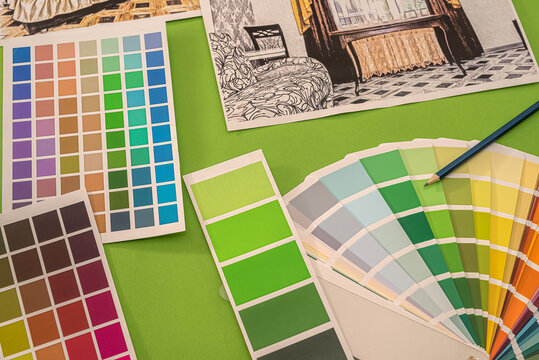 on a green background laid out colored palettes, samples and drawings of the house with a pencil