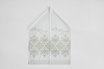 White embroidered wedding towels on a white background.