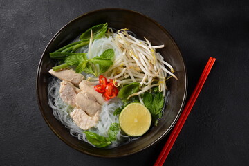Pho Ga soup  with chicken, rice noodles and fresh herbs in a bowl. Vietnamese cuisine - obrazy, fototapety, plakaty