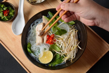 Pho Ga soup  with chicken, rice noodles and fresh herbs in a bowl. Vietnamese cuisine - obrazy, fototapety, plakaty