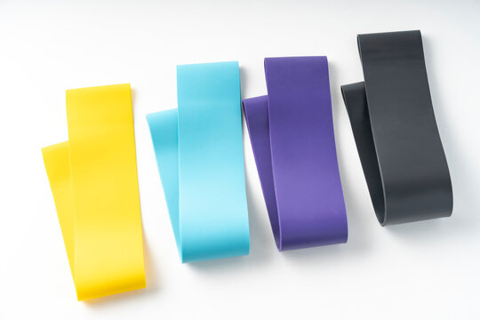 A set of colorful elastic fitness band. Expanders for women and weight loss on white background Flat layer of various fitness bands, space for text Elastic elastic bands for fitness, selective focus