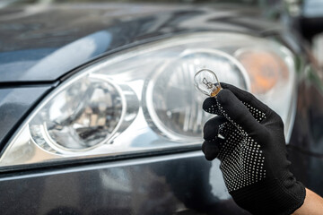 mechanic change low-beam or high-beam light bulb in his car © RomanR