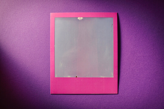Grape square frame on table. Blank square colored Polaroid photo frame copy space 