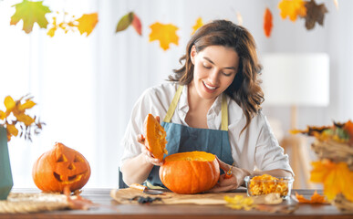 woman is carving pumpkin