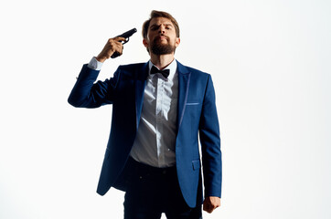Fototapeta premium Man with a pistol in hand crime detective killer light background