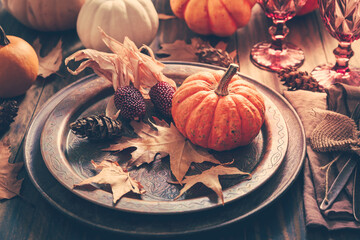 Place setting for Thanksgiving with pumpkins and autumn leaves