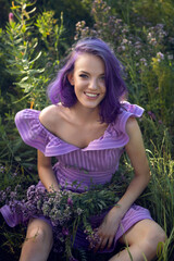 teenage girl with dyed purple hair and a nose piercing in the grass with a bouquet