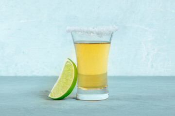 Tequila shot with a lime slice, Mexican liquor with a salted rim, side view