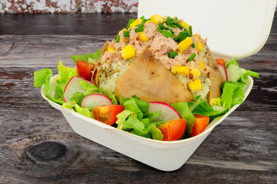 Tuna fish and sweet corn filled baked jacket potato with fresh salad in a take away box