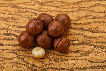 Brown macadamia nut heap over background