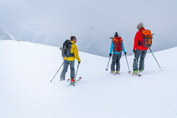 Ski-Alpinisten bei der gemeinsamen Abfahrt im freien Gel&auml;nde bei schlechter Sicht