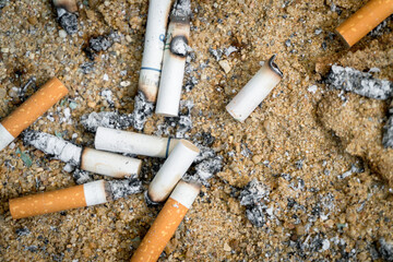 Bangkok/Thailand-July ‎20 ‎2021: Numerous cigarette butts that were left on the sand and ash,...