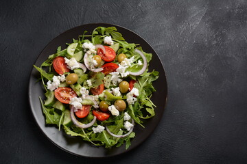 Greek salad of fresh cucumber, tomato, lettuce, red onion, feta cheese and olives with olive oil.